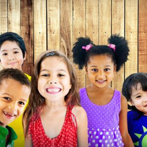 A group of five diverse children smiling at the camera
